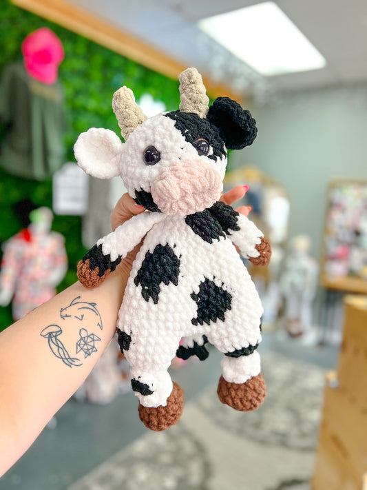 white + black cow snuggler